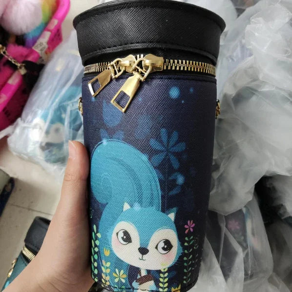 Cylindrical navy blue pencil case with a cartoon blue squirrel and floral design, gold zipper