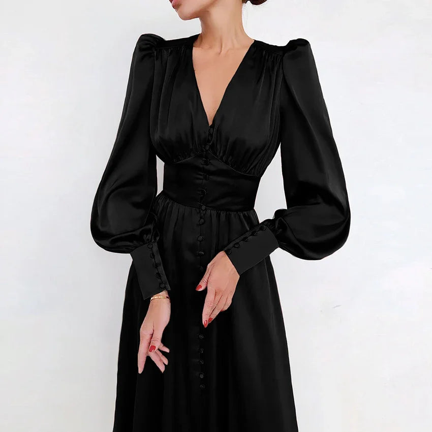 Woman wearing elegant black satin dress with puff sleeves and button details
