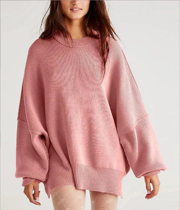 Woman wearing oversized pink ribbed knit sweater with long balloon sleeves in studio