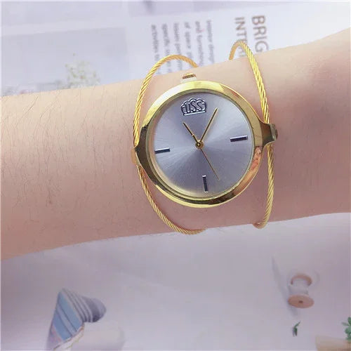 Elegant gold wristwatch with silver dial and minimal markings on woman's arm