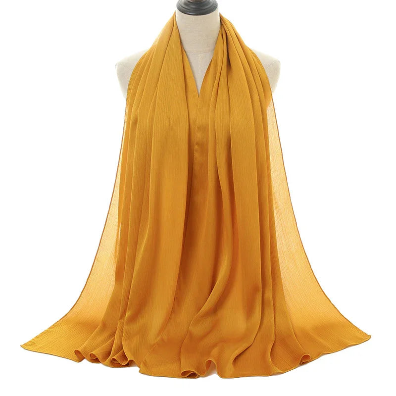 Mustard yellow lightweight chiffon scarf displayed on a white mannequin bust