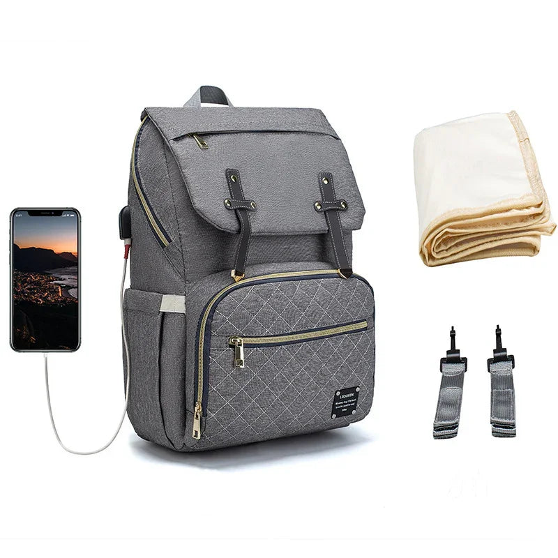 Gray diaper backpack with multiple pockets, USB charging port, baby changing mat, and stroller straps
