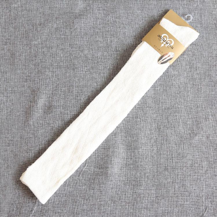 Single white textured sock with beige hanger packaging on gray fabric background