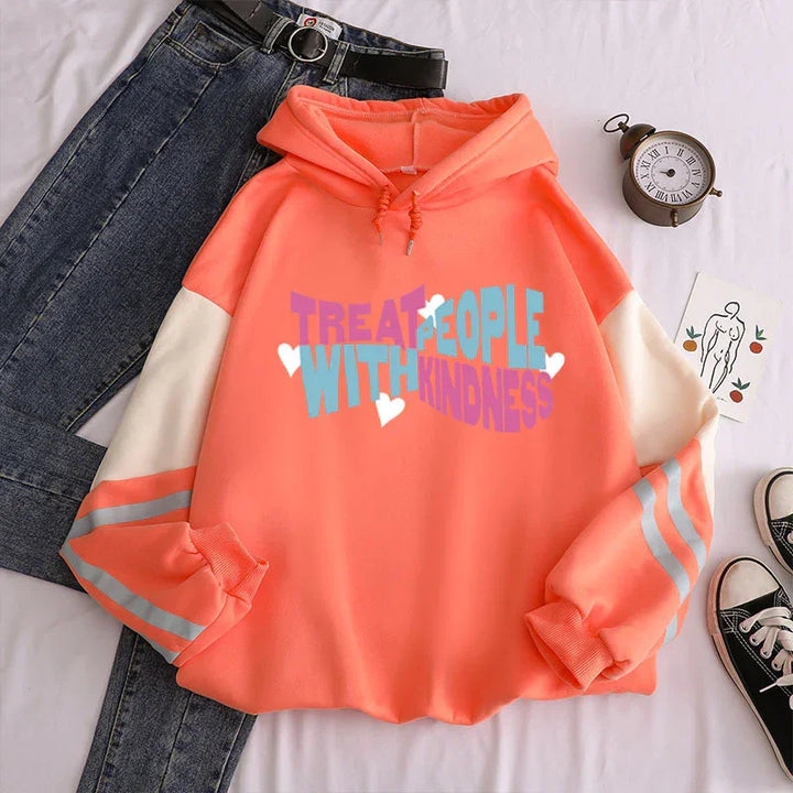 Coral pink hoodie with white sleeves and reflective stripes, blue jeans, vintage clock, and sneakers on white background