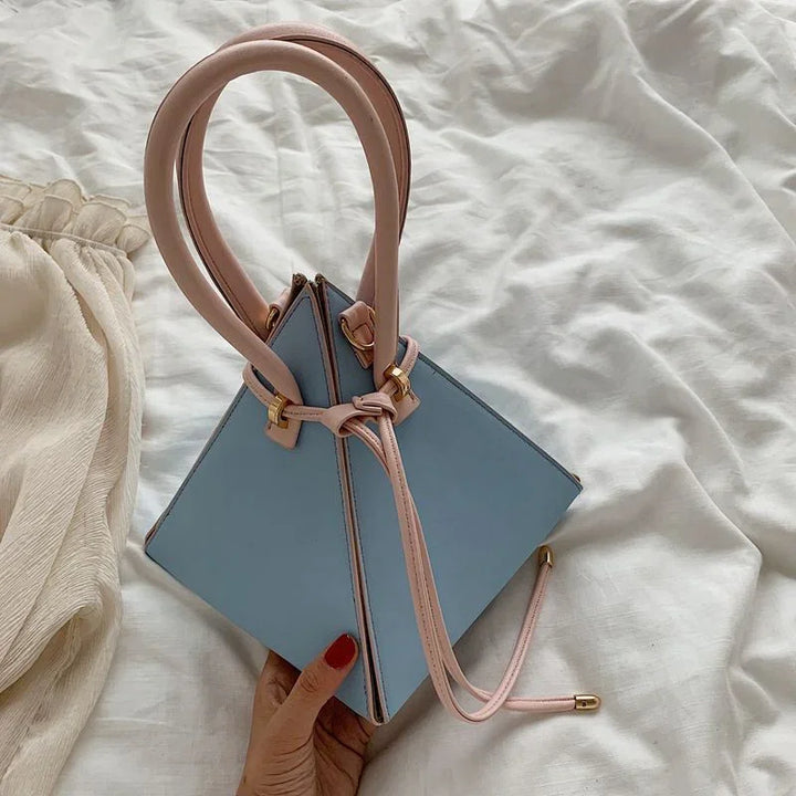 Woman holding stylish blue tote bag with light pink handles and drawstring on white fabric background