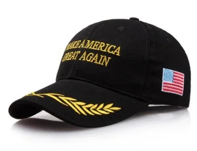 Black baseball cap with gold embroidered text 'Make America Great Again', gold laurel design on brim, and American flag patch on side