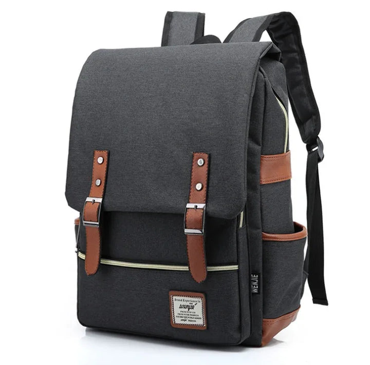 Gray canvas backpack with brown leather straps, front pocket, and padded shoulder straps