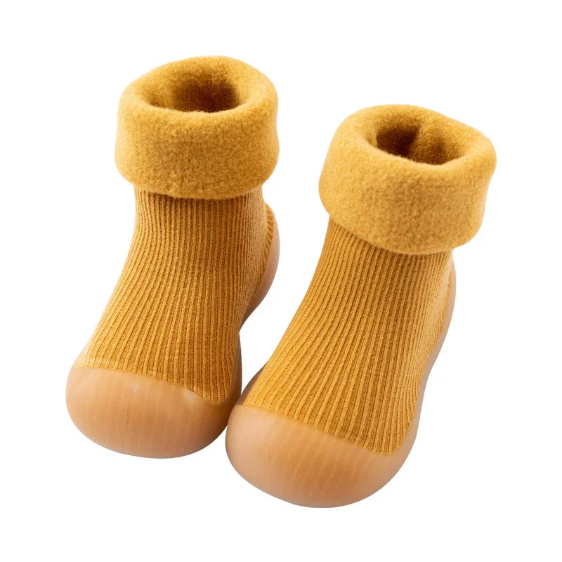 Pair of mustard yellow toddler indoor shoes with ribbed knit upper and fold-over fleece cuffs