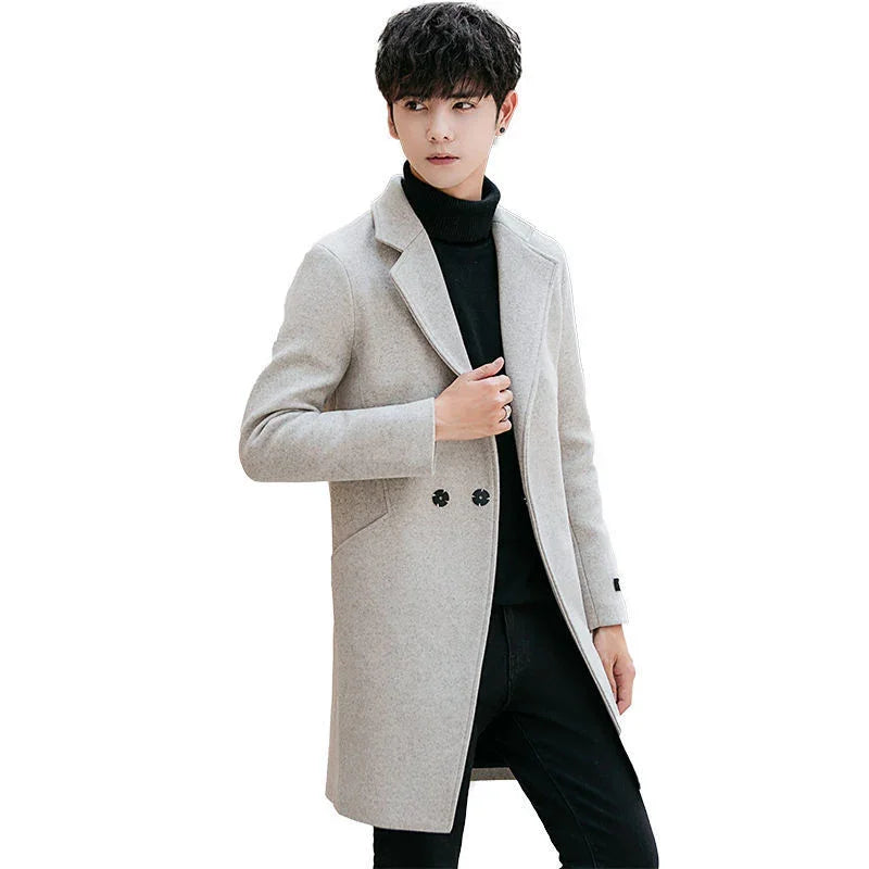 Young man wearing stylish light gray wool coat over black turtleneck and black pants on white background
