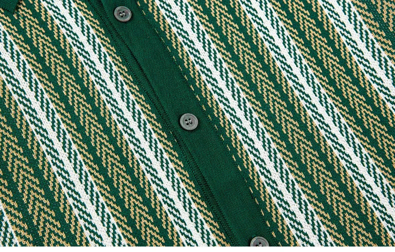 Close-up of green knit cardigan with chevron pattern in white and beige and black buttons