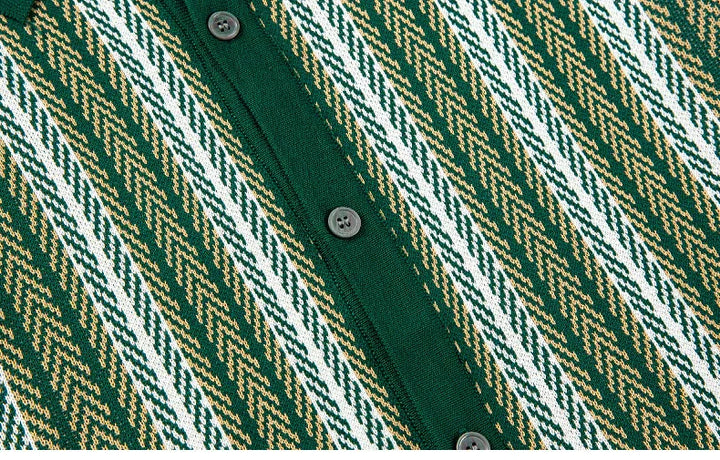 Close-up of green knit cardigan with chevron pattern in white and beige and black buttons