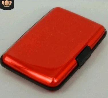 Compact red aluminum wallet with black latch on gray surface