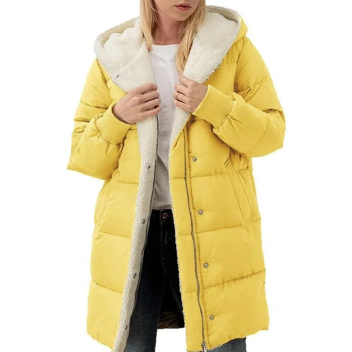 Woman wearing yellow puffer jacket with white sherpa lining and hood on white background