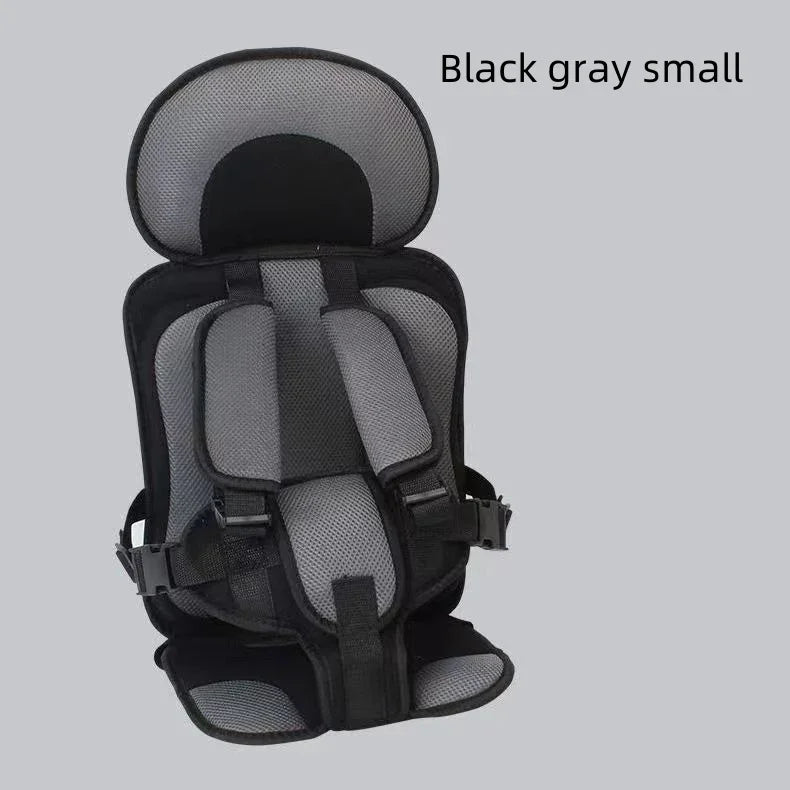 Black and gray small child safety seat with padded straps and headrest on gray background