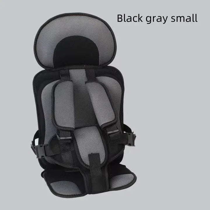 Black and gray small child safety seat with padded straps and headrest on gray background
