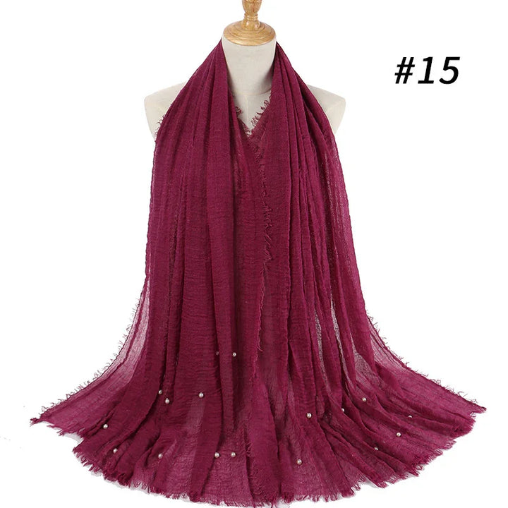 Dark red lightweight scarf with pearl embellishments displayed on mannequin