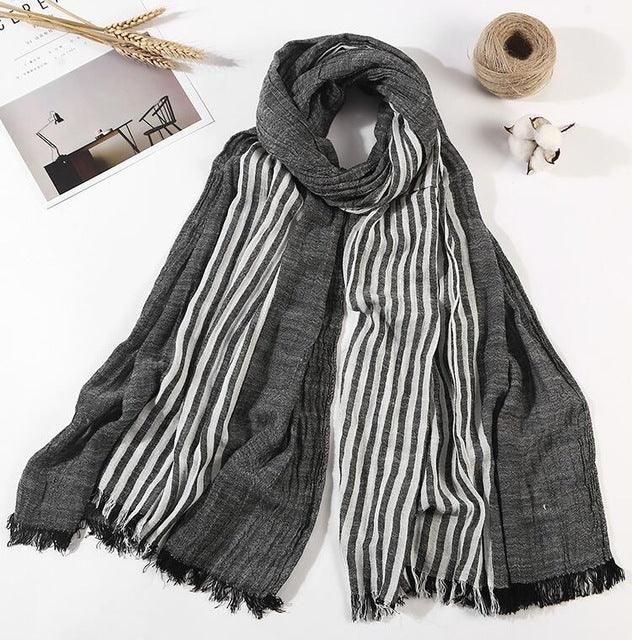 Elegant dark gray scarf with white vertical stripes and fringed edges on white background