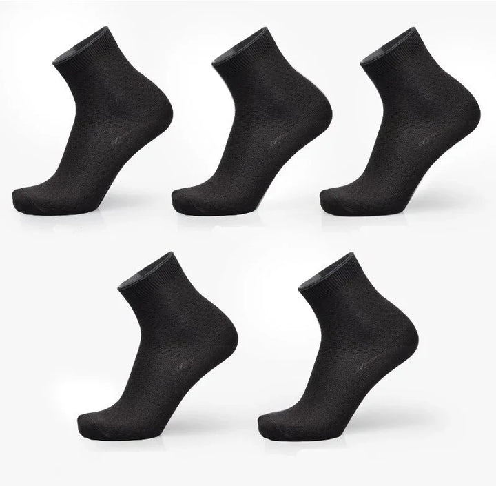 Five pairs of plain black ankle socks displayed on white background