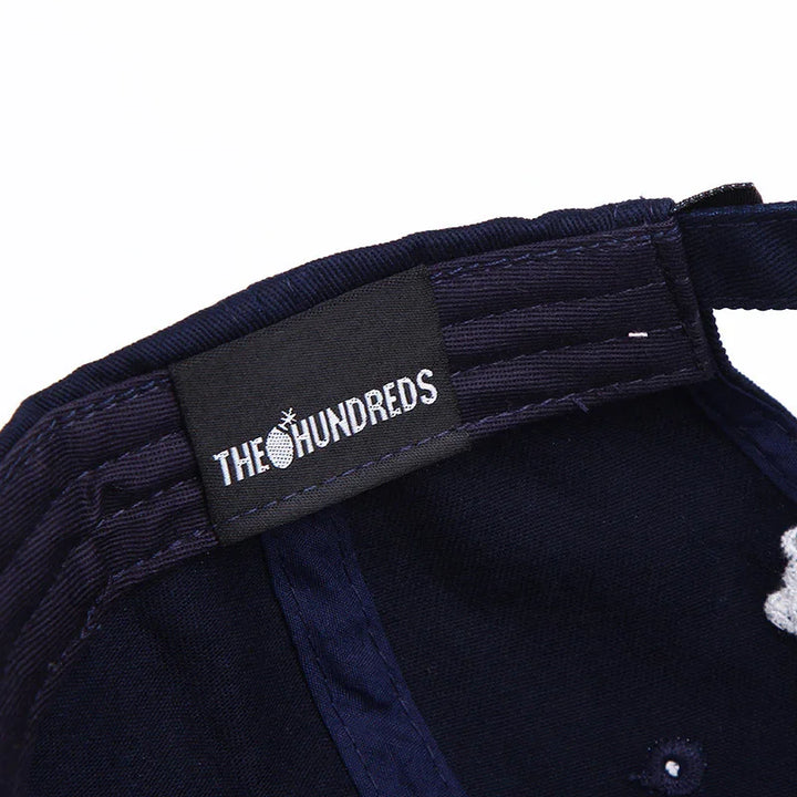 Close-up of navy blue cap interior with The Hundreds brand label and stitched detailing