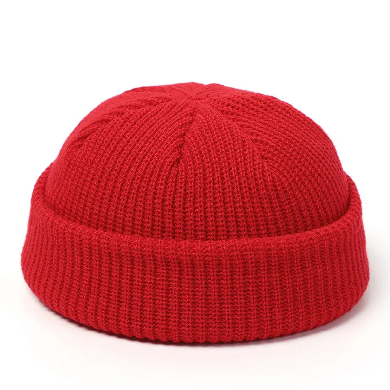 Red knit beanie hat with folded cuff, cozy winter accessory on white background