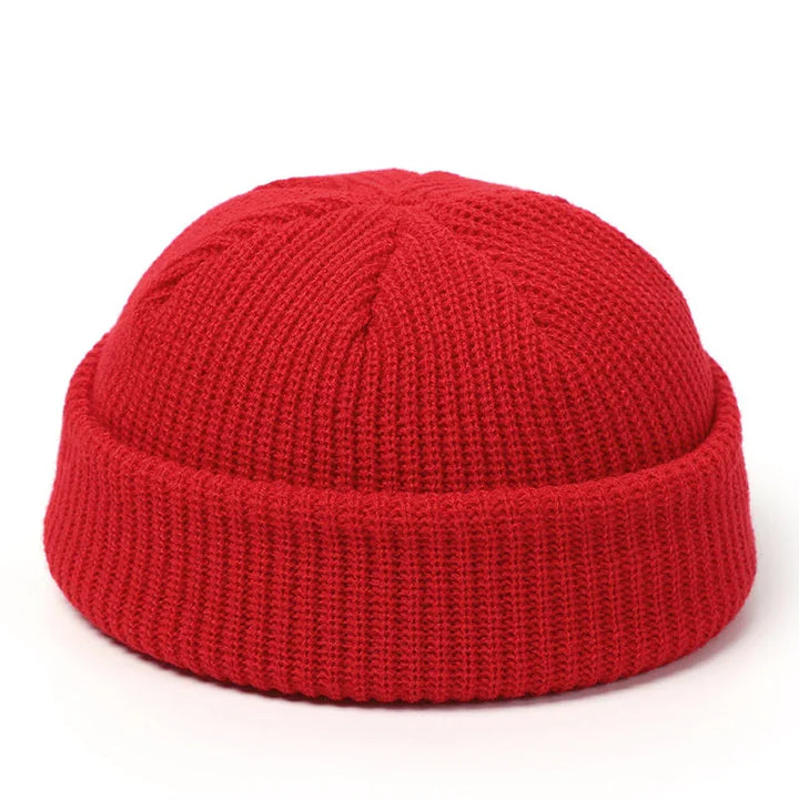 Red knit beanie hat with folded cuff, cozy winter accessory on white background