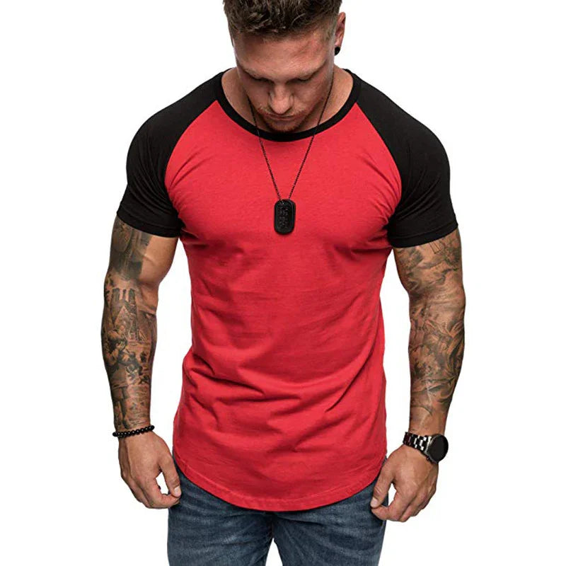 Muscular man with tattoos wearing a red and black raglan sleeve t-shirt and blue jeans