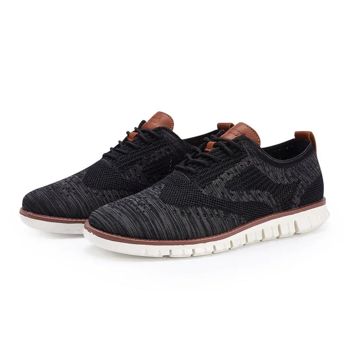 Black knit casual sneakers with white flexible sole and brown leather accents on heel and tongue