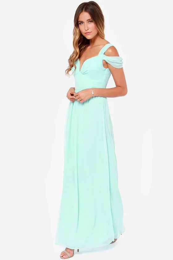 Woman wearing a light blue off-shoulder evening gown with flowing skirt and strappy heels