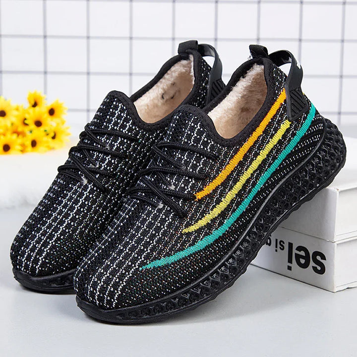 Black knit sneakers with colorful orange, yellow, and teal stripes and fuzzy inner lining on box