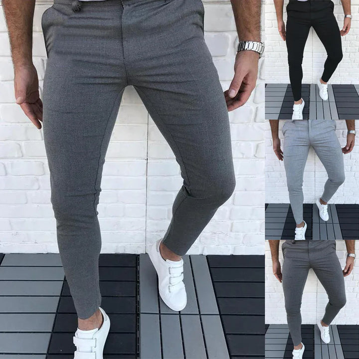 Men's slim fit casual pants in gray, black, and light gray worn with white sneakers on outdoor deck