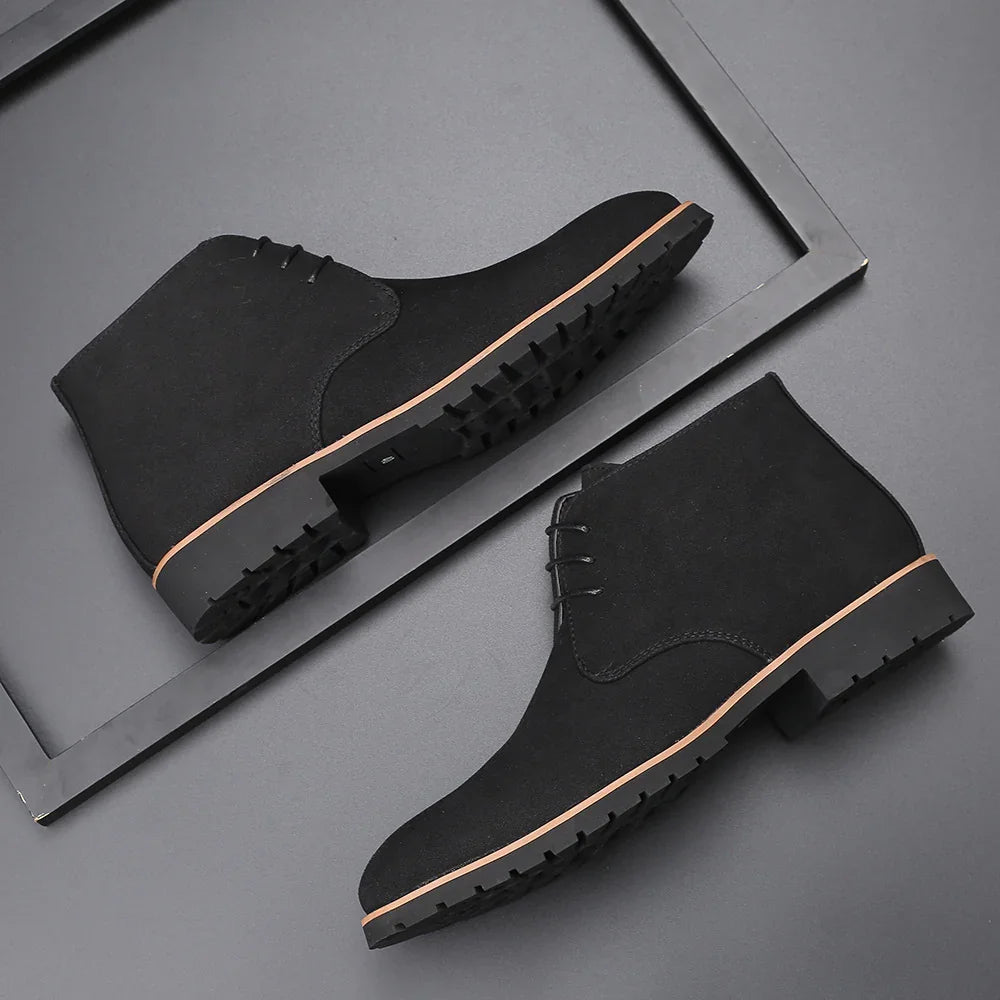 Black suede men's ankle boots with rubber soles displayed on grey background