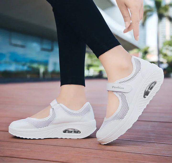 White breathable mesh women’s sneakers with air cushion sole worn with black leggings outdoors
