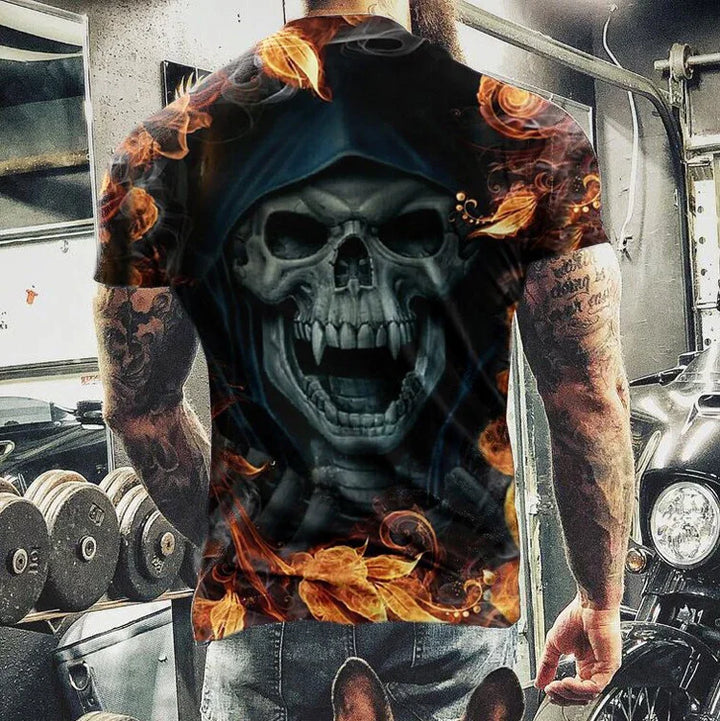 Man wearing black t-shirt with fiery skull design in gym setting with weights and motorcycle