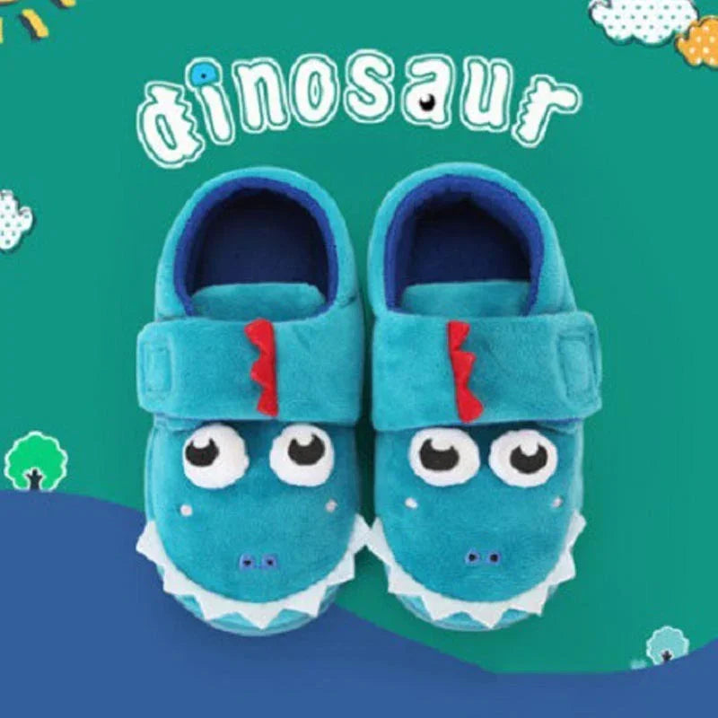 Cute blue dinosaur-themed toddler slippers with big eyes and red spikes on green background