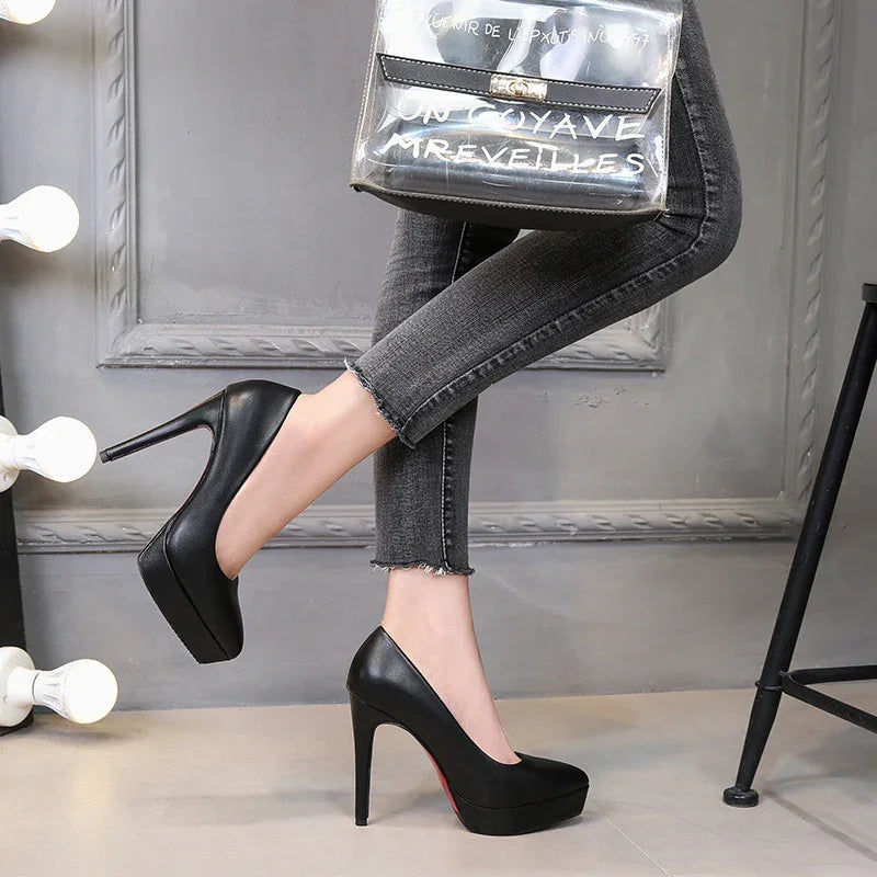 Black high heel platform pumps worn with grey frayed skinny jeans in stylish indoor setting