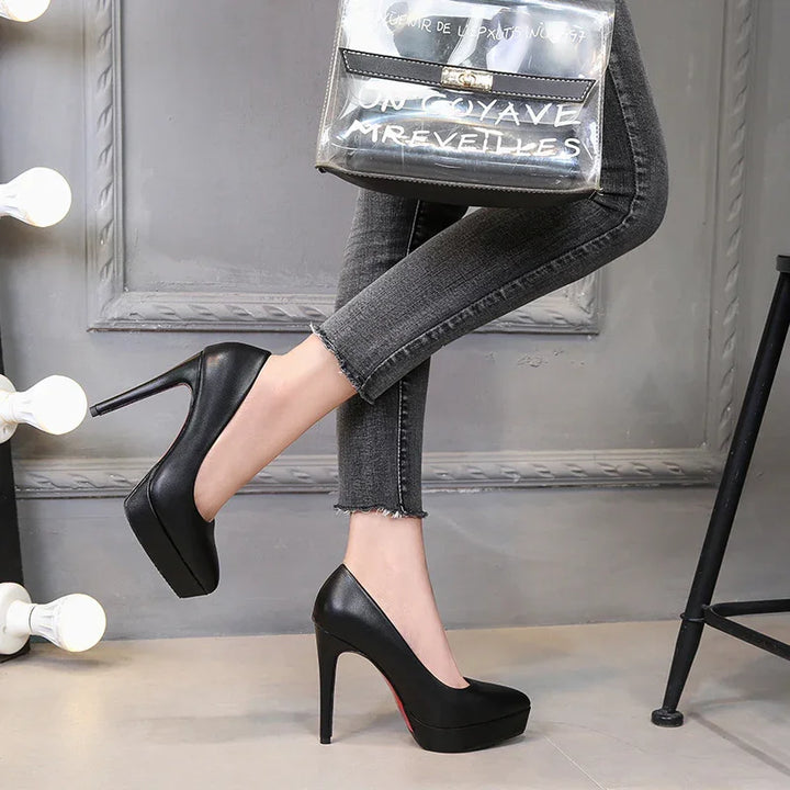 Black high heel platform pumps worn with grey frayed skinny jeans in stylish indoor setting