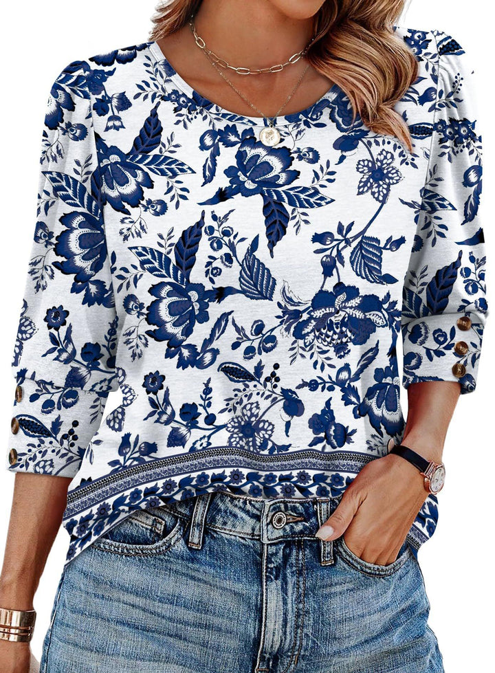 White blouse with blue floral pattern, three-quarter sleeves with button details, paired with denim jeans.