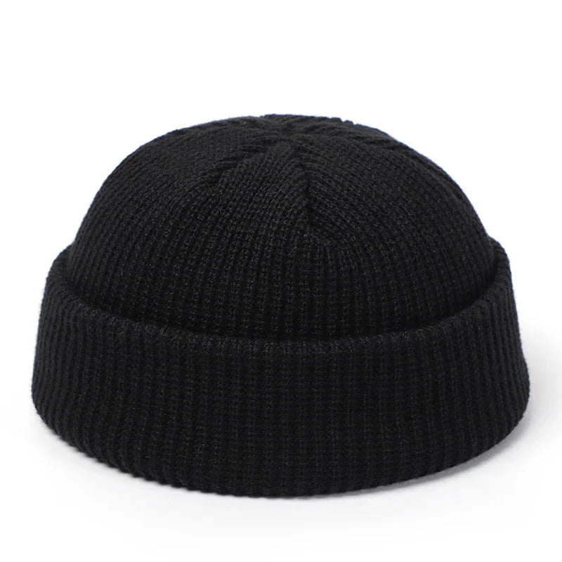 Black knit cuffed beanie hat isolated on white background