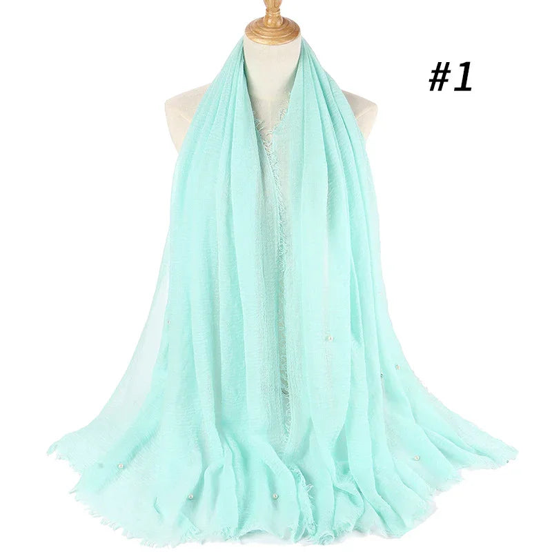 Light blue soft chiffon scarf with delicate pearl accents displayed on mannequin