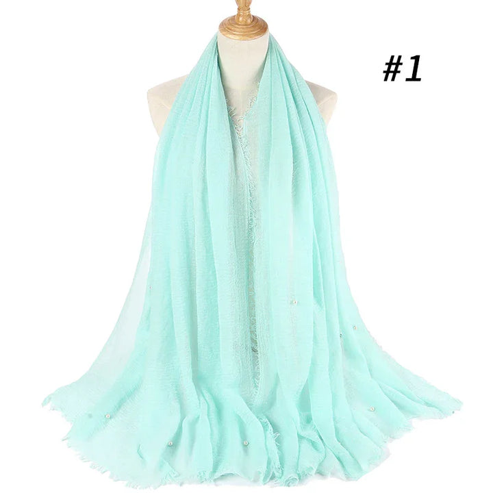 Light blue soft chiffon scarf with delicate pearl accents displayed on mannequin