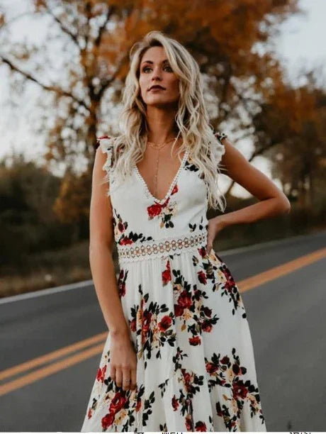 Blonde woman in a white floral dress standing on an empty road with autumn trees in the background
