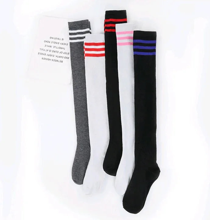 Five pairs of knee-high socks in gray, white, and black with colored stripes in white, red, pink, and blue