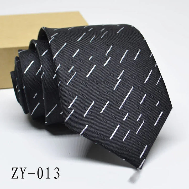 Black necktie with white diagonal stripe pattern, displayed rolled with a beige box in the background