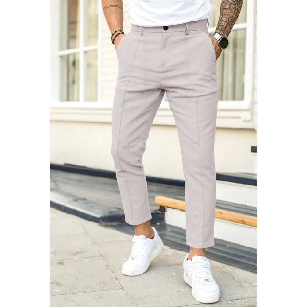 Man wearing light beige slim fit cropped trousers tucked in white sneakers outdoors