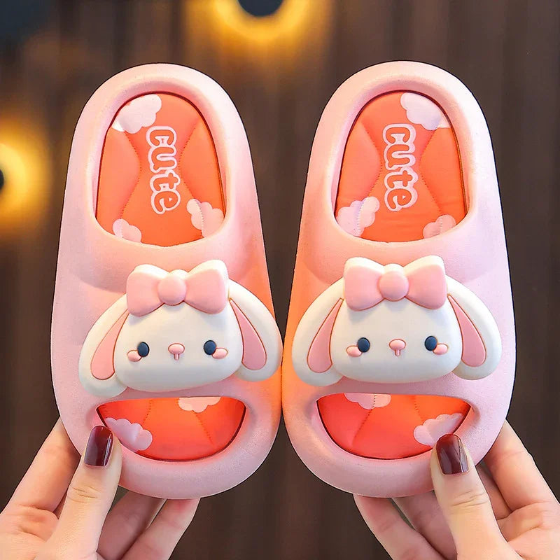 Pink cute bunny slippers with bows on orange cloud-patterned insoles held by hands