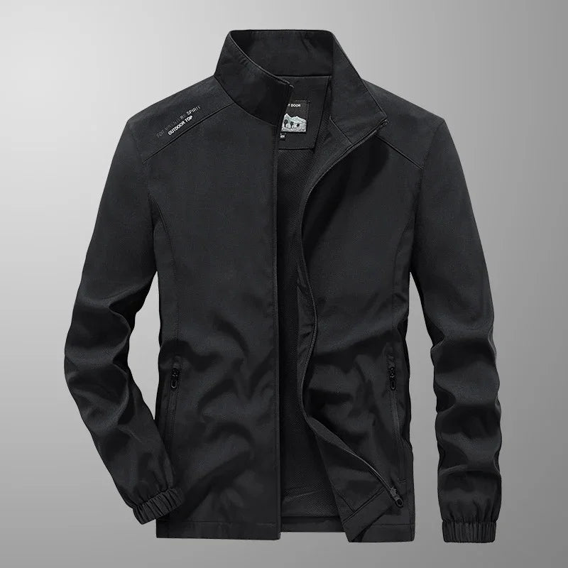 Black men's outdoor jacket with zippered pockets and stand collar on gray background