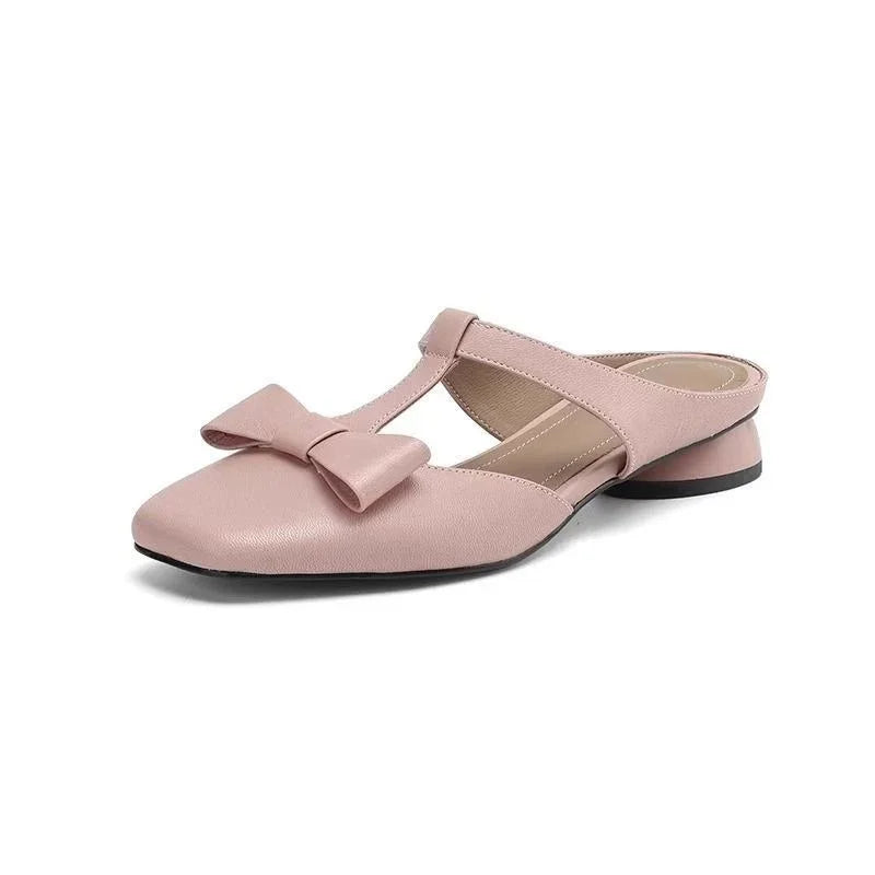 Pink slip-on women's mule with low block heel and bow detail on white background