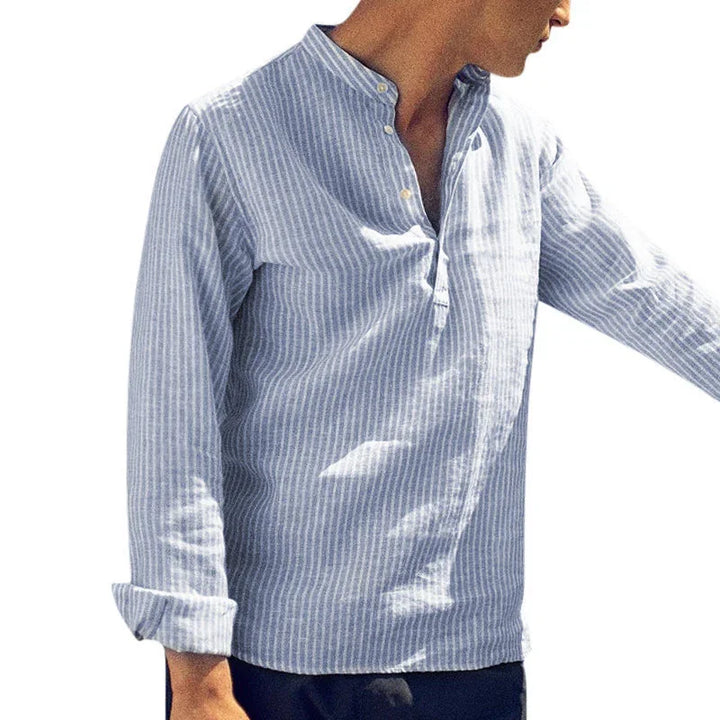 Man wearing light blue and white striped mandarin collar linen shirt with rolled sleeves