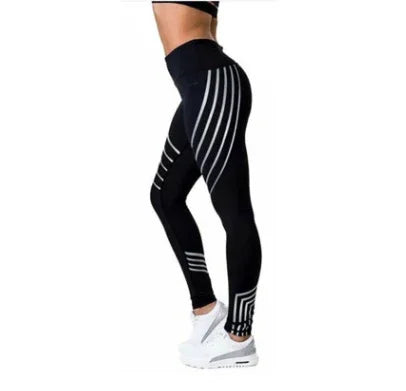 Side view of woman wearing black high-waisted leggings with white stripe patterns and white sneakers