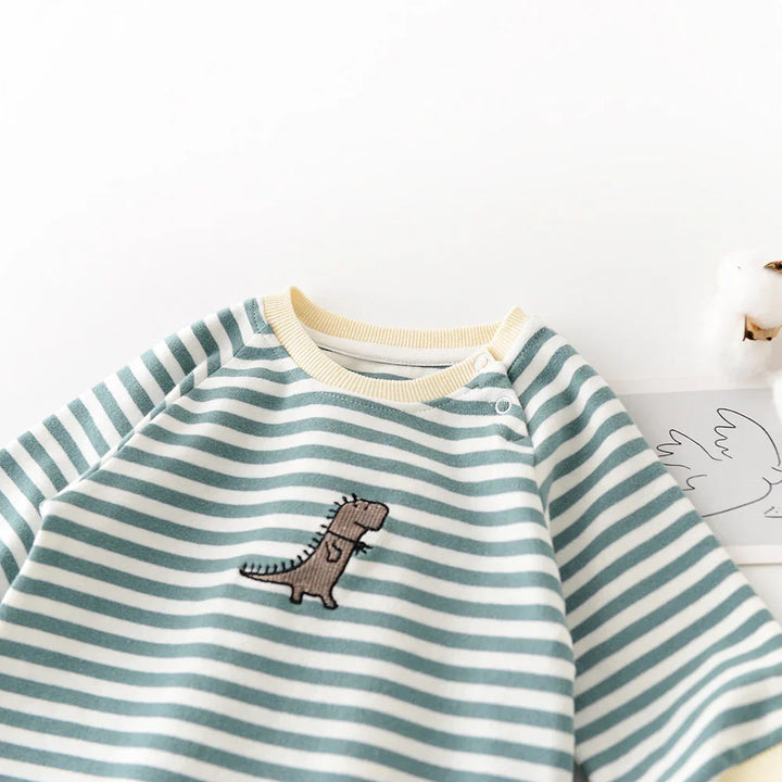 Striped baby sweater with green and white lines and a small brown dinosaur embroidery on chest